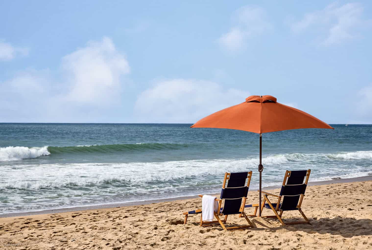 Beach chairs and orange umbrella facing the Atlantic Ocean at Marram Montauk