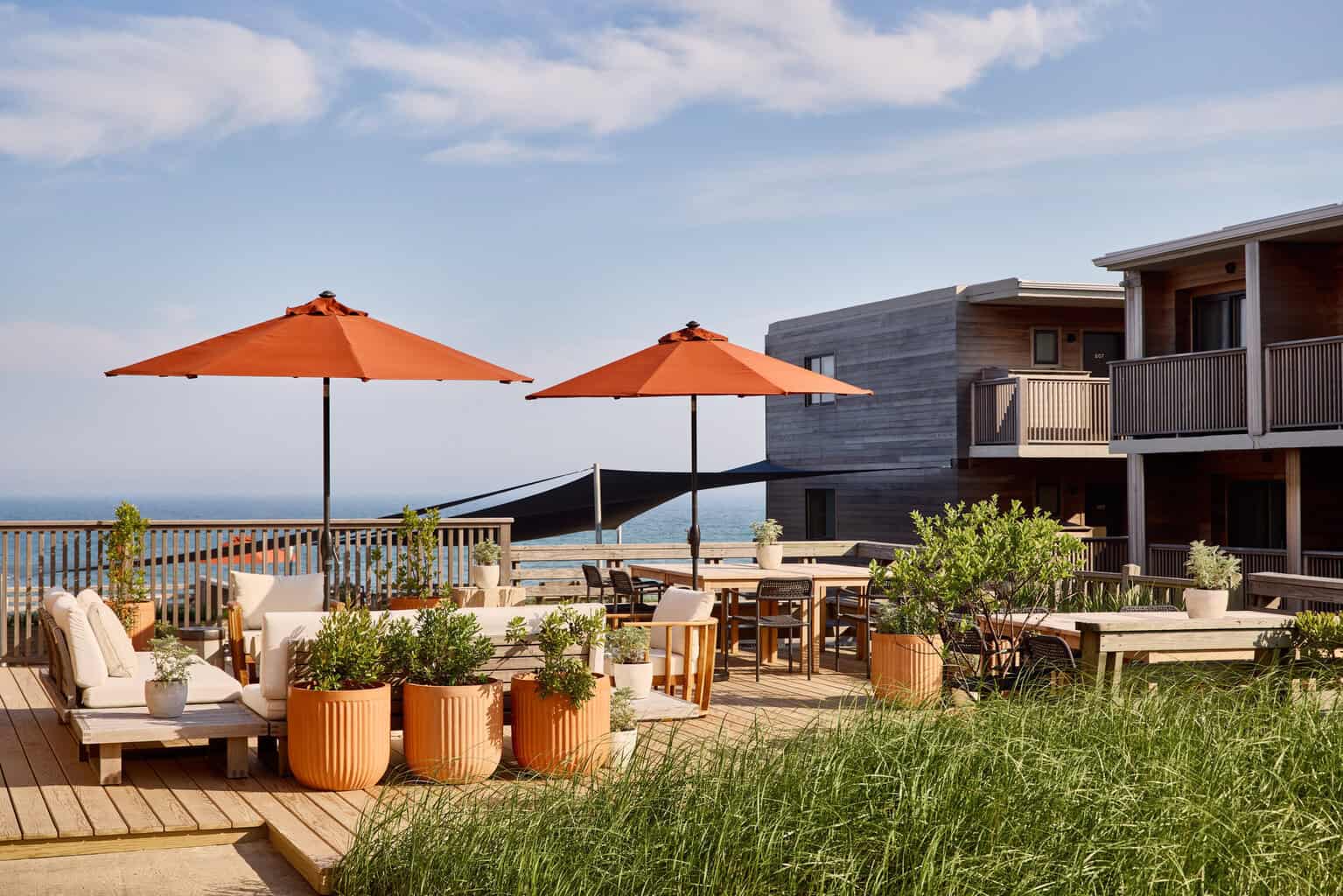 Marram Montauk outdoor deck with orange umbrellas and ocean backdrop
