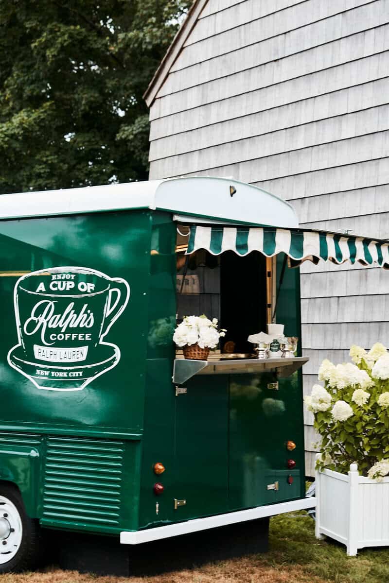 Green Ralph's Coffee truck with striped awning parked at Mulford Farm in East Hampton during the summer residency.