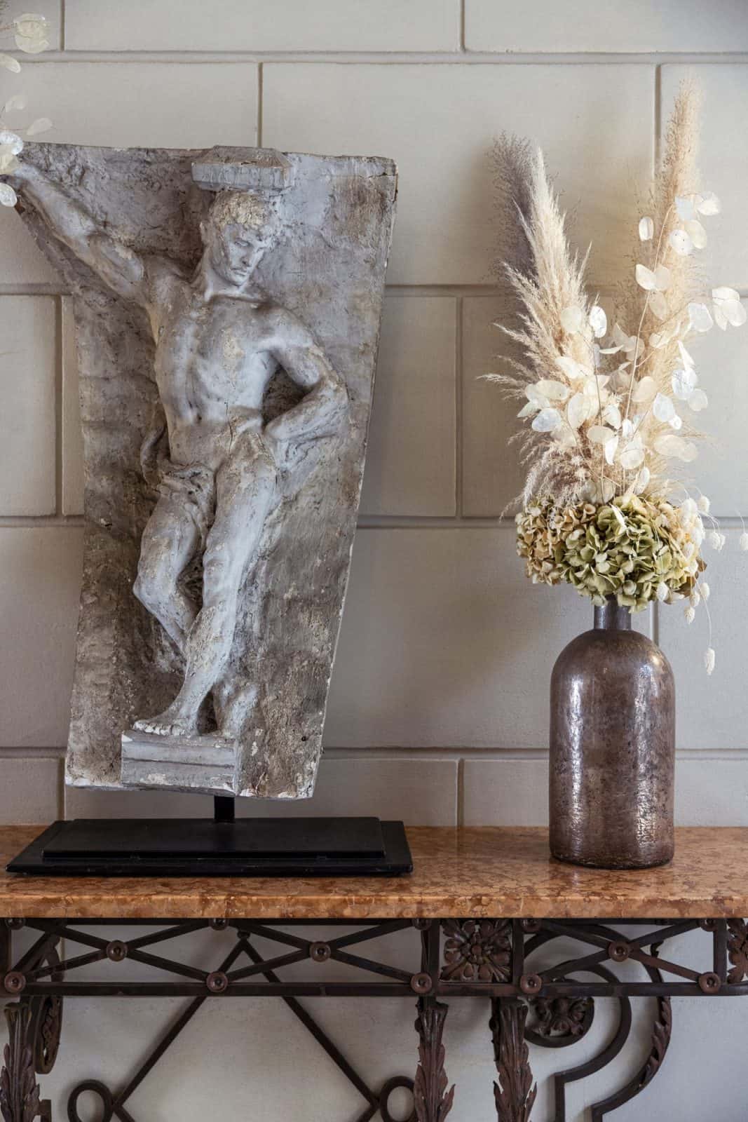  An antique relief and dried arrangement on a console at J.K. Place Paris