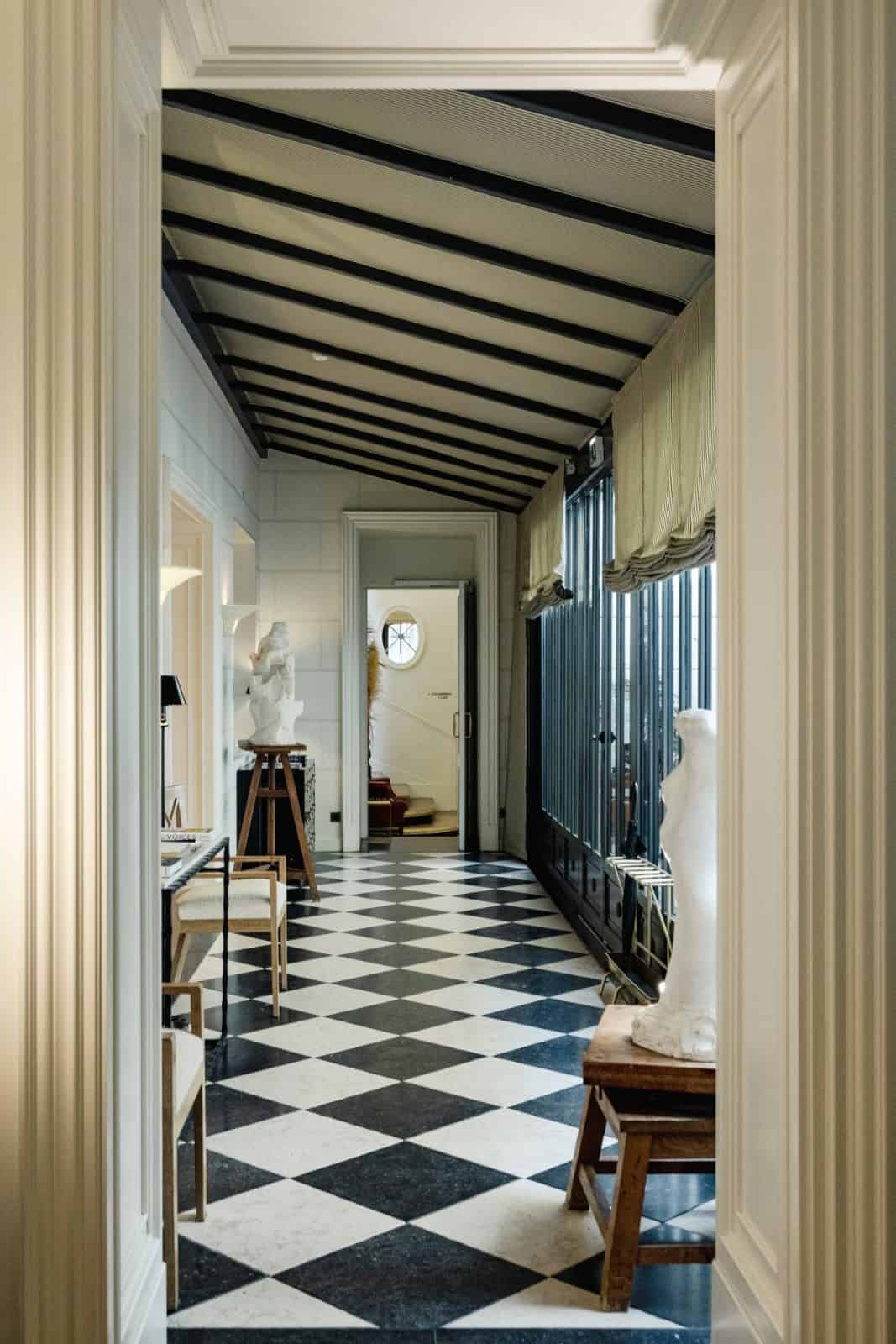 Black-and-white checkerboard tile in a hallway at J.K. Place Paris