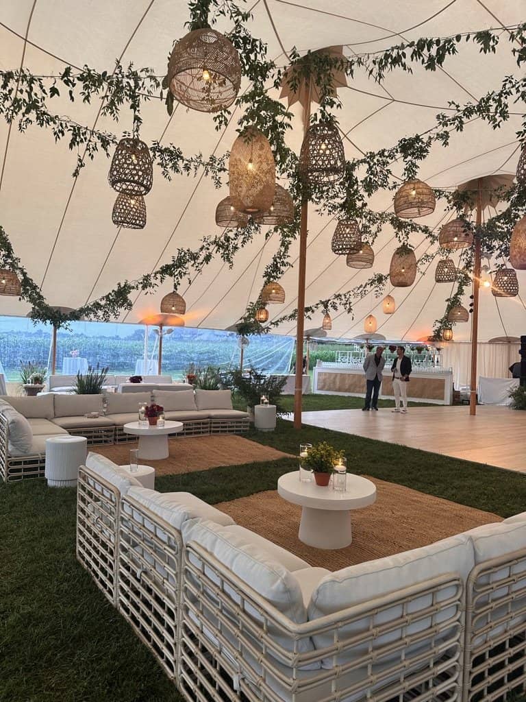 Decco lounge settings under a sailcloth tent with an ocean view