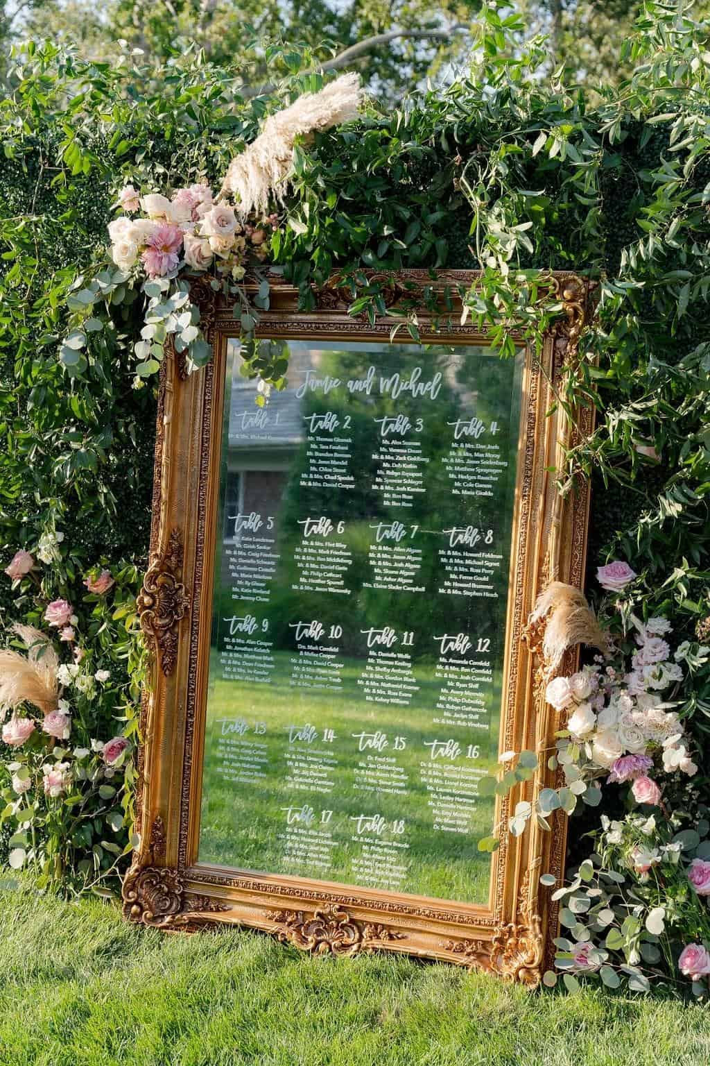 A floral gold mirror seating chart styled by Decco