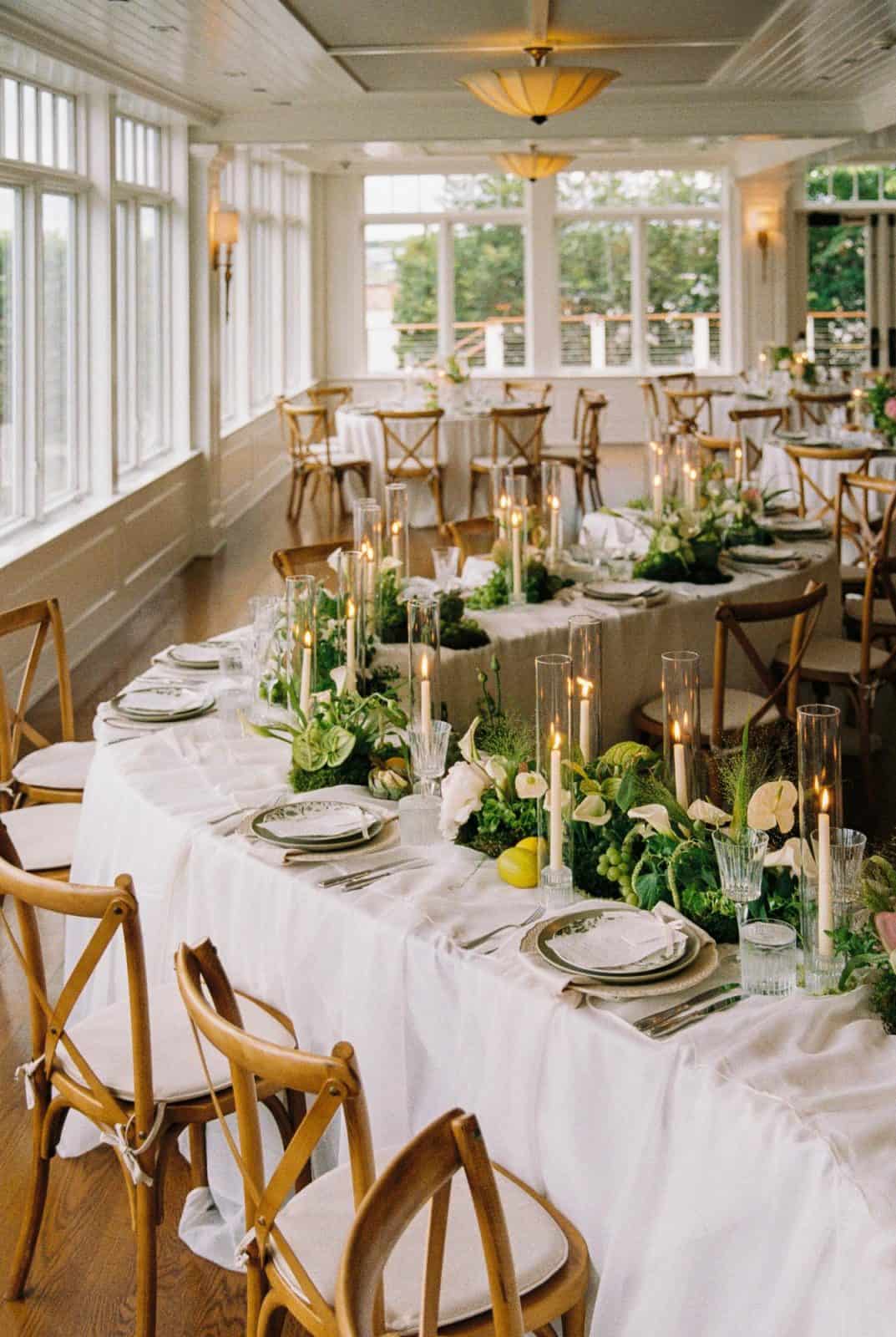 A Decco tablescape with wood chairs and greenery at a Hamptons celebration